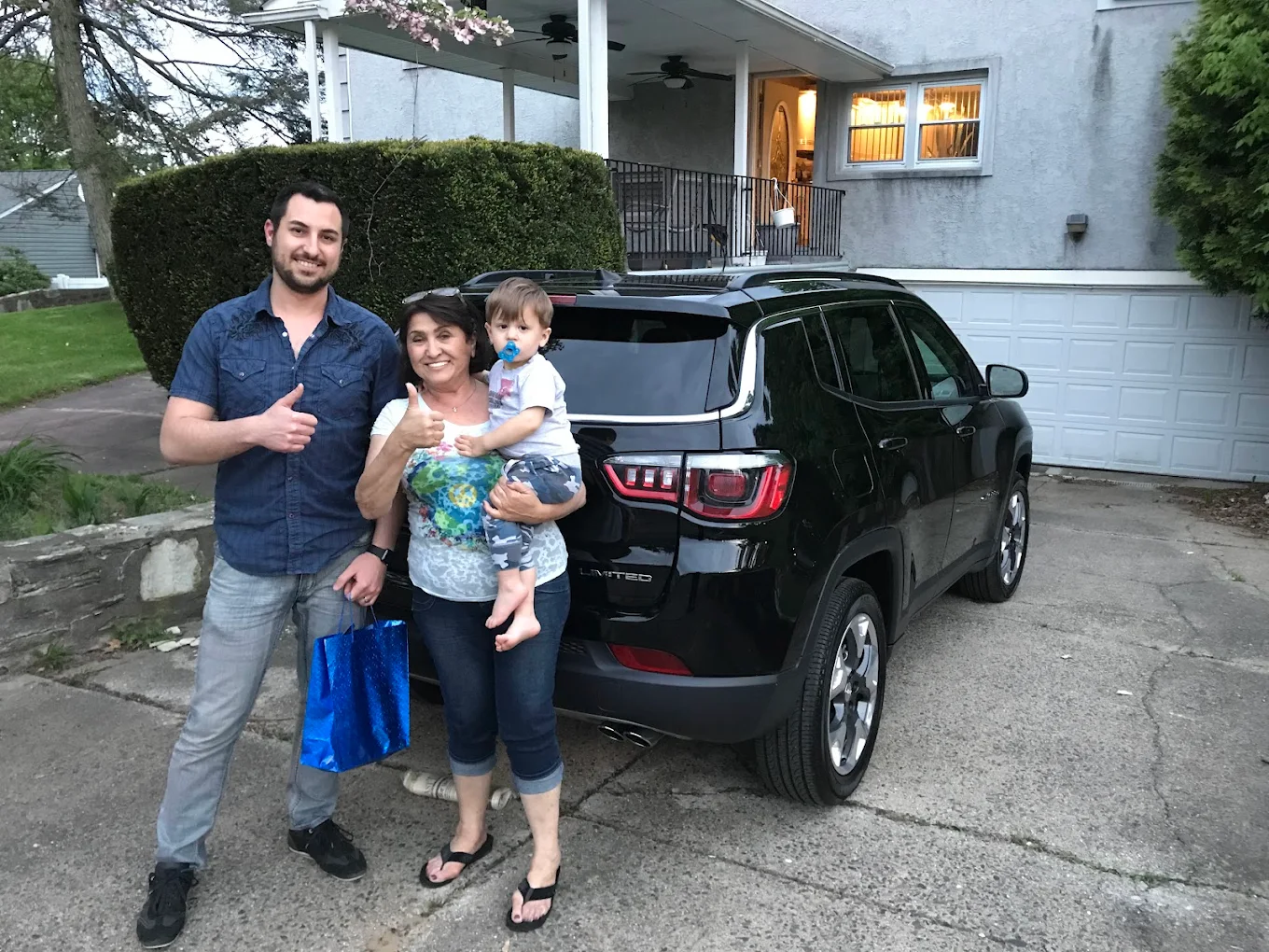Family with their newly delivered Jeep outside their home