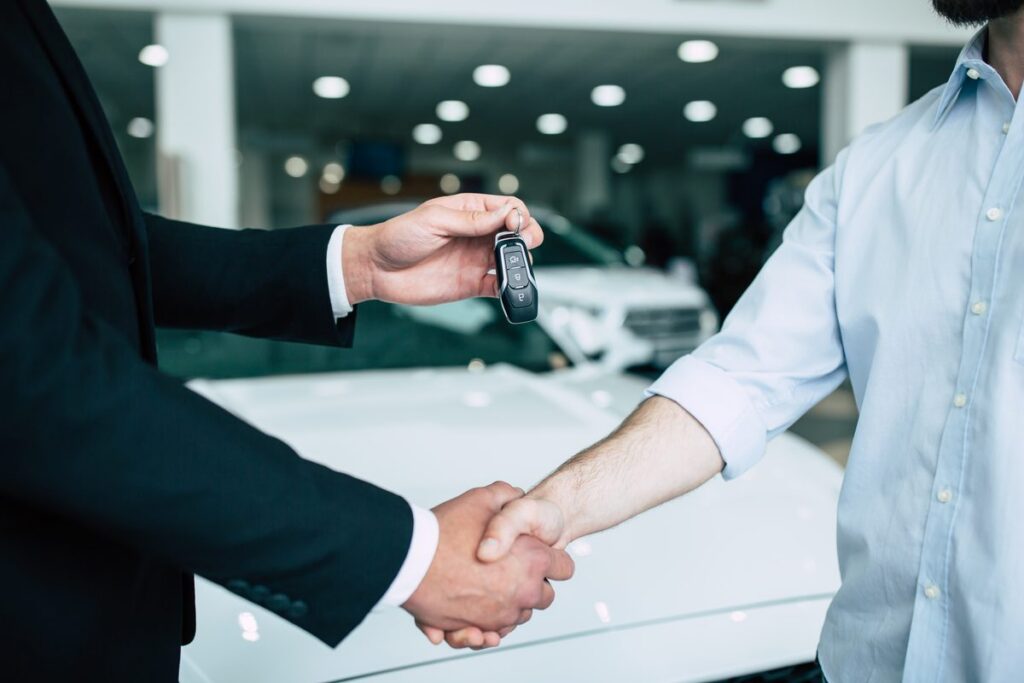 Handshake and car keys handed over at a lease signing